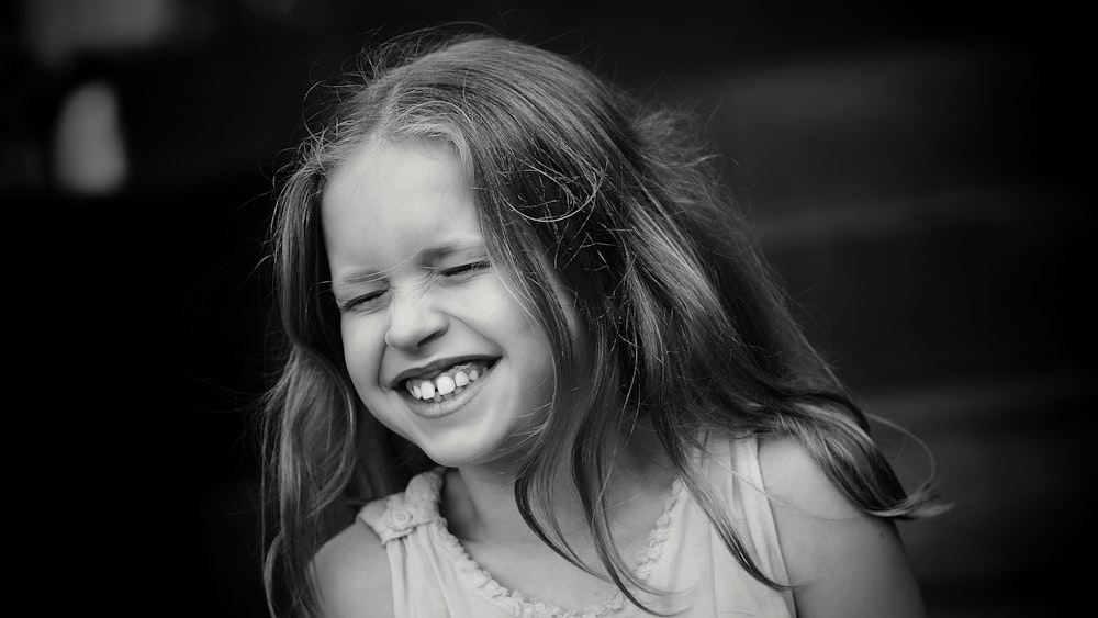 a little girl laughing with her hair blowing in the wind