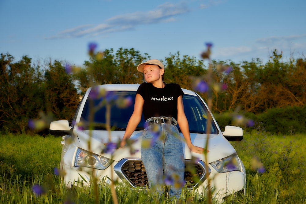 a boy sitting on the hood of a car