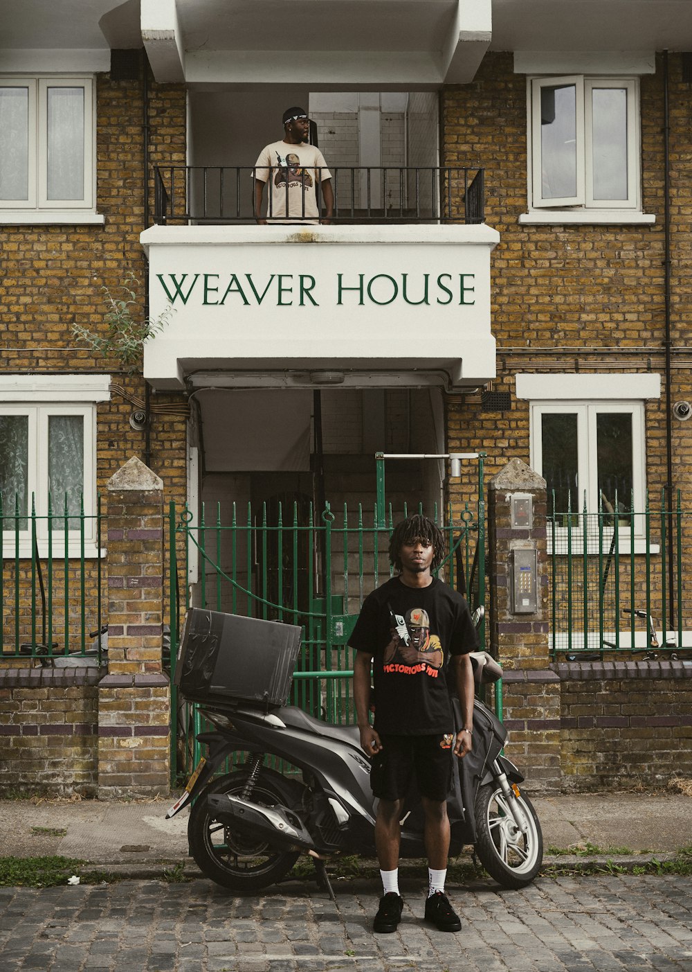 a man standing next to a motorcycle in front of a building