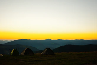 A scenic view of the Dios Padre water park with festival tents and camping areas under a twilight sky.