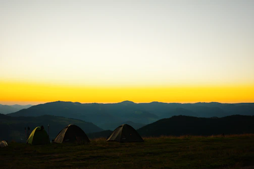 A scenic view of the Dios Padre water park with festival tents and camping areas under a twilight sky.