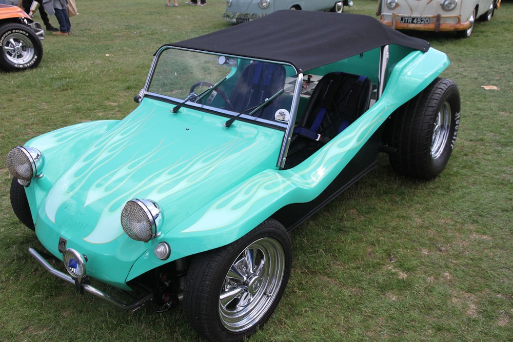 a blue car parked on top of a lush green field