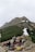 Group of hikers resting with backpacks near a scenic hilltop at Chandrashila peak.