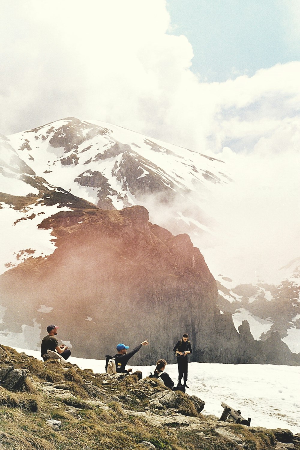 a group of people standing on top of a snow covered mountain