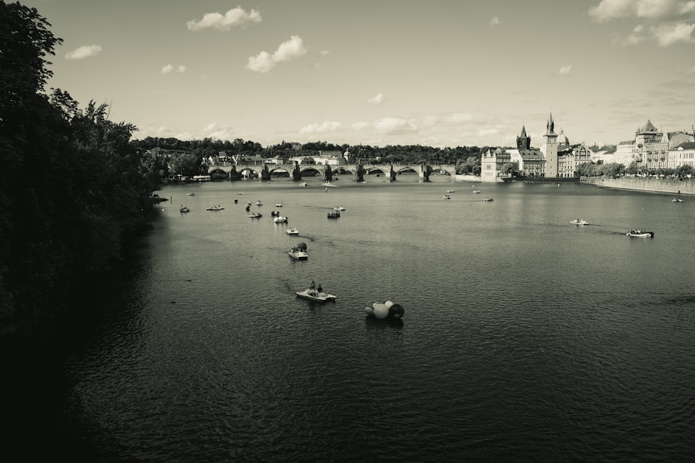 a black and white photo of boats on a river