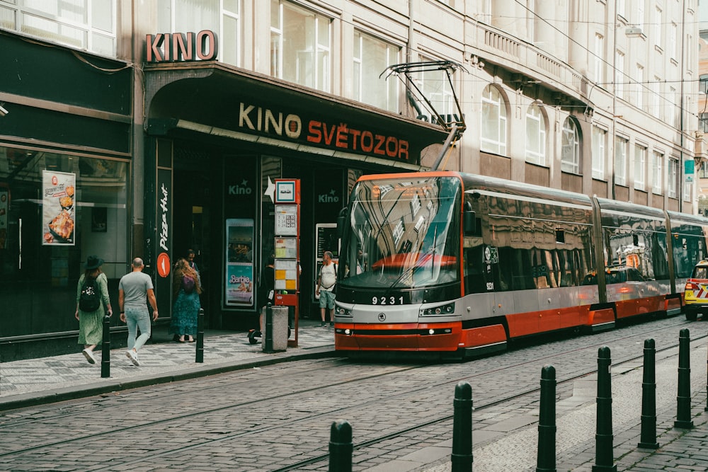 a red and silver bus on a city street