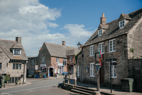 Historic stone buildings lining a quaint Yorkshire village street on a sunny day.