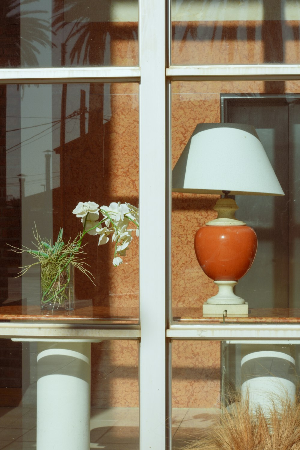 a lamp sitting on top of a table next to a window