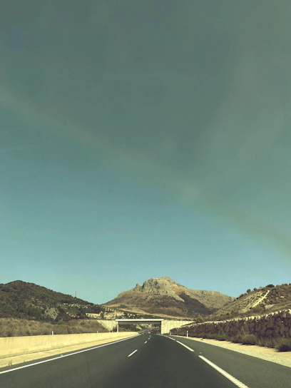 A panoramic view of a newly constructed highway winding through the rugged Afghan landscape under a clear blue sky.