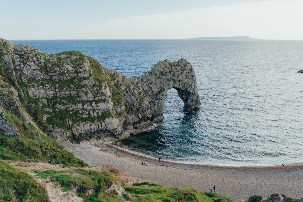 a beach with a rock arch in the middle of it