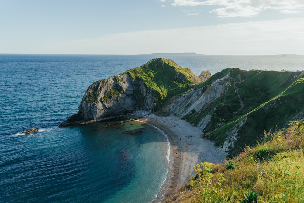 a view of a beach from a hill overlooking the ocean