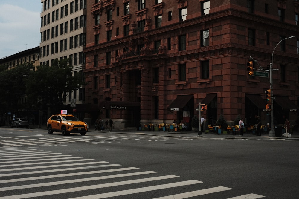 a yellow taxi driving down a street next to tall buildings