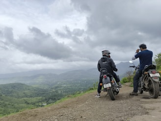 A group of riders pausing at a scenic overlook with rolling hills stretching into the distance.