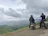 Group of bikers pausing on a hilltop overlooking lush Costa Rican landscape.