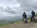 Group of bikers pausing on a hilltop overlooking lush Costa Rican landscape.