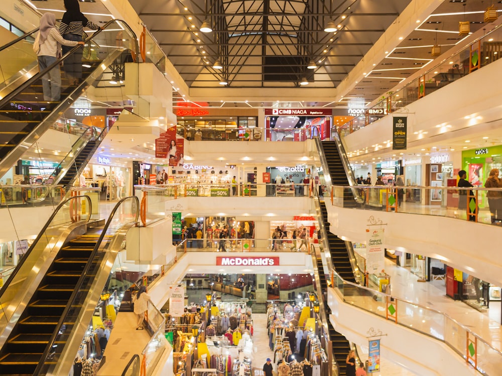 a mall filled with lots of people and escalators