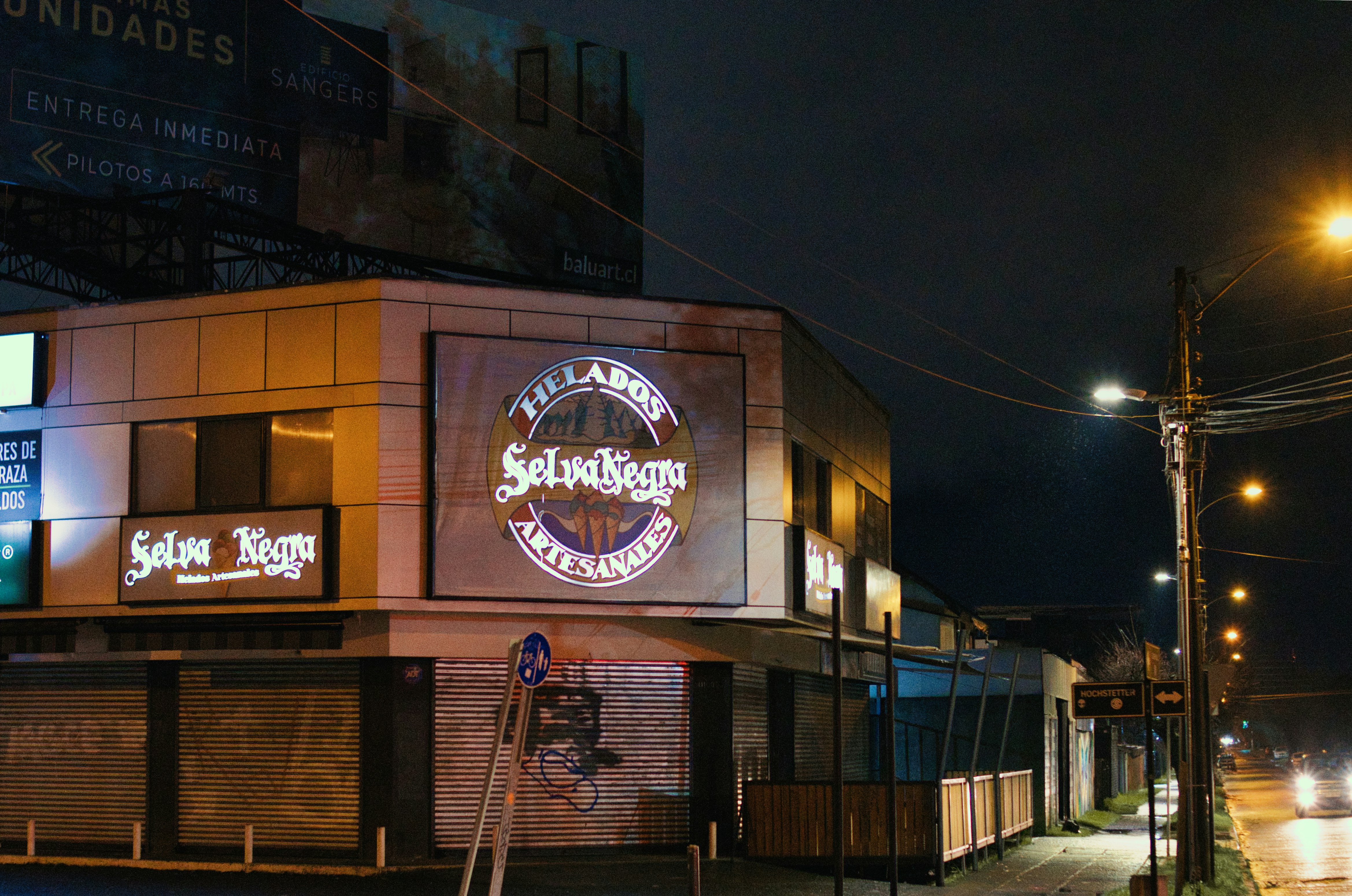 a street corner at night with a building lit up