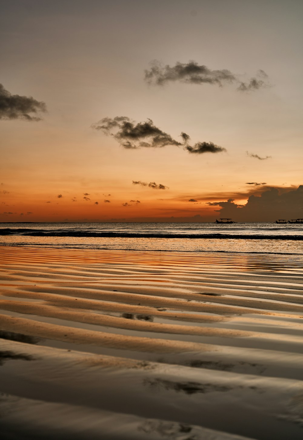 the sun is setting over the water at the beach