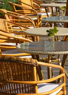 a row of wicker chairs and tables on a patio