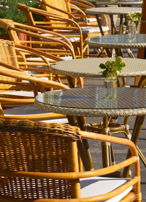 a row of wicker chairs and tables on a patio
