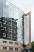 A stunning modern building with glass facades reflecting the sky.