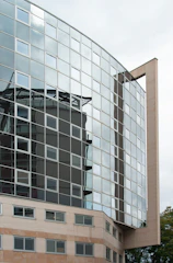 Modern business building with mirrored glass facade reflecting urban surroundings