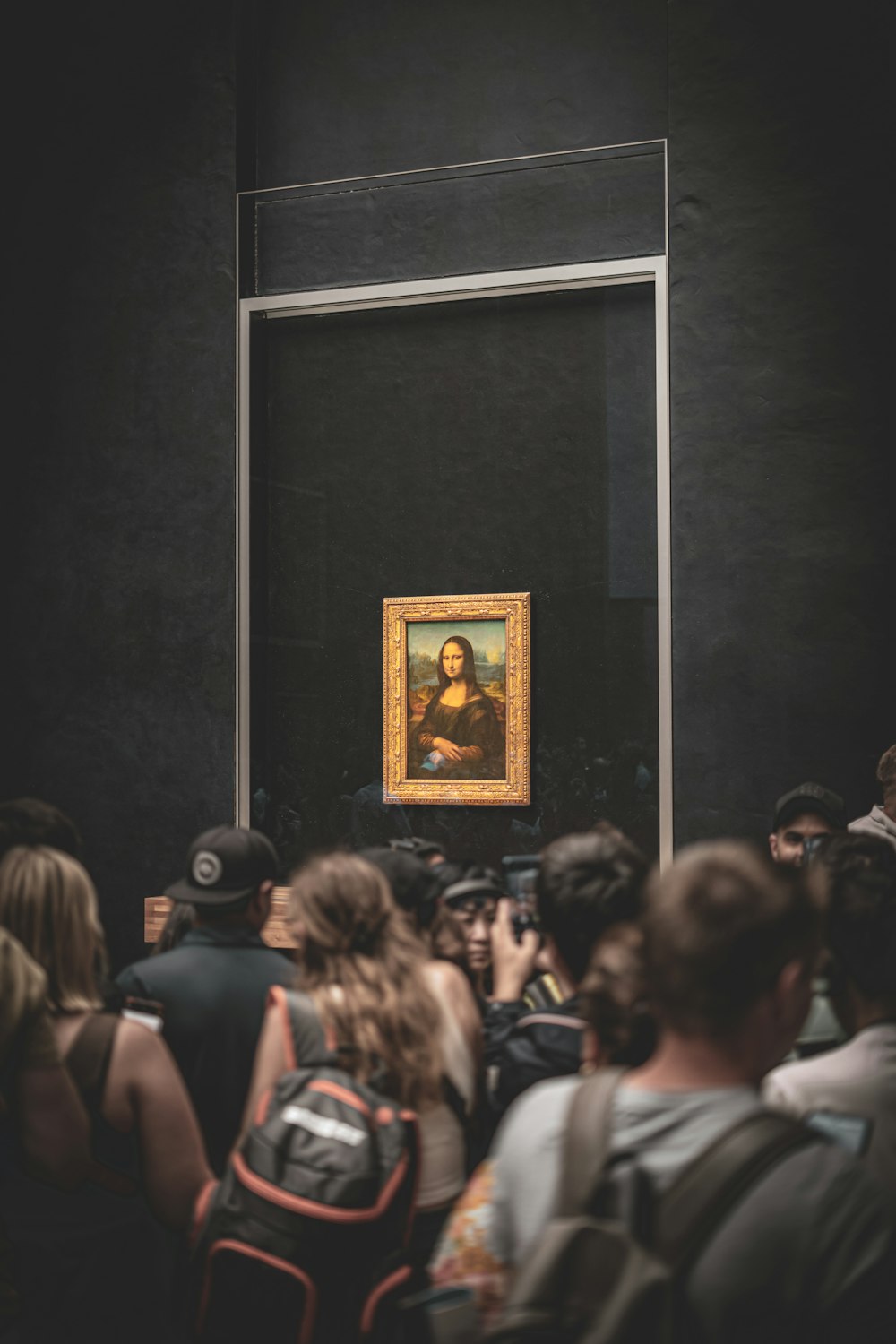 a group of people standing in front of a painting