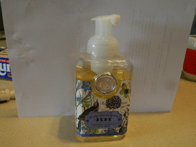 An elegant soap dispenser with a floral design on a countertop.