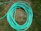 Close-up of a sturdy PVC garden hose coiled neatly on a green lawn