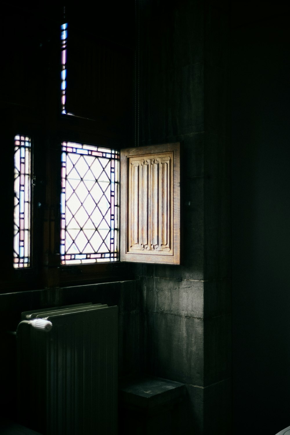 a dark room with a window and a radiator
