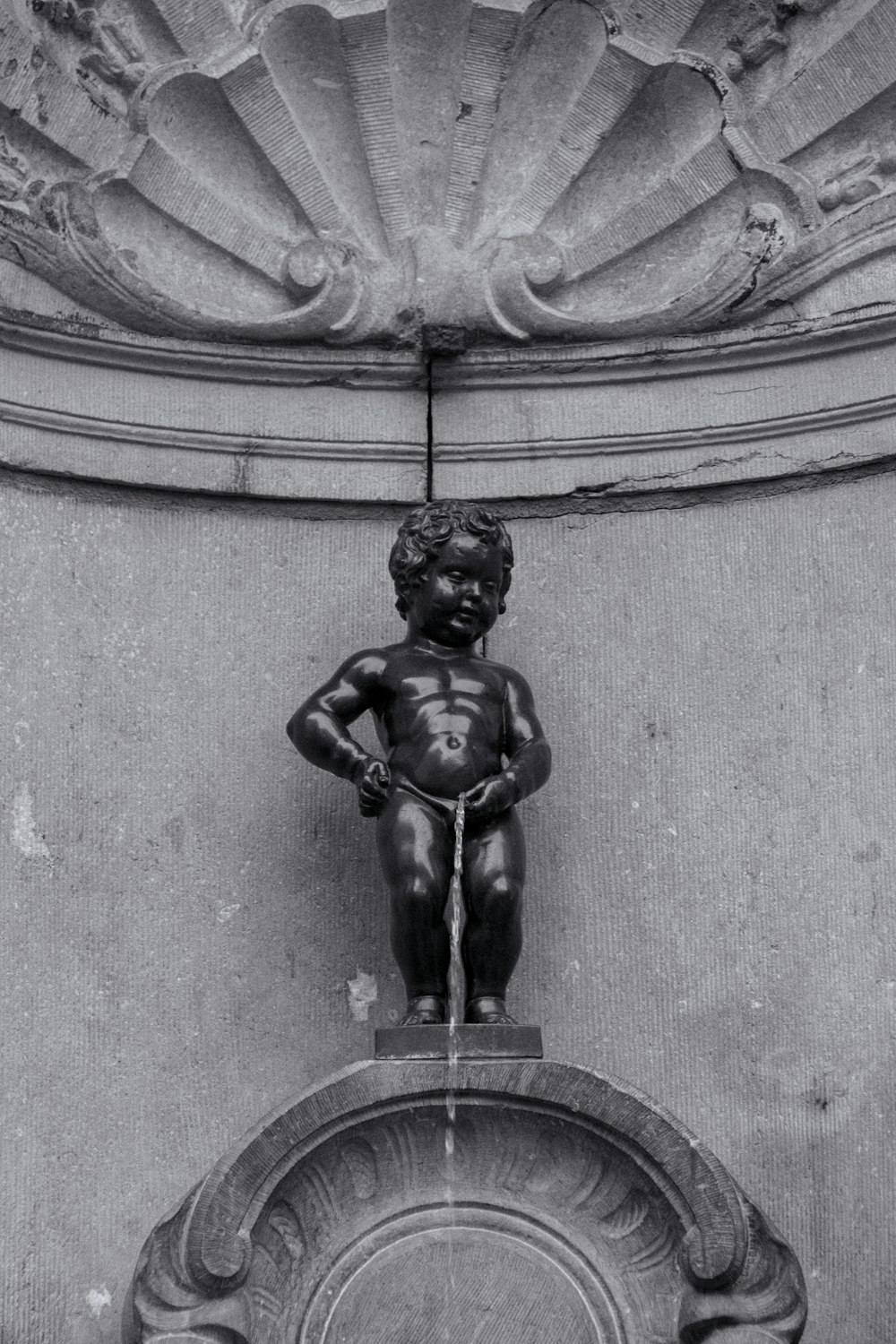 a black and white photo of a water fountain