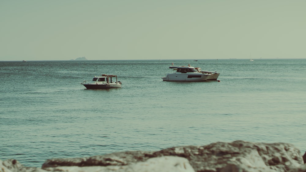 a couple of boats floating on top of a large body of water