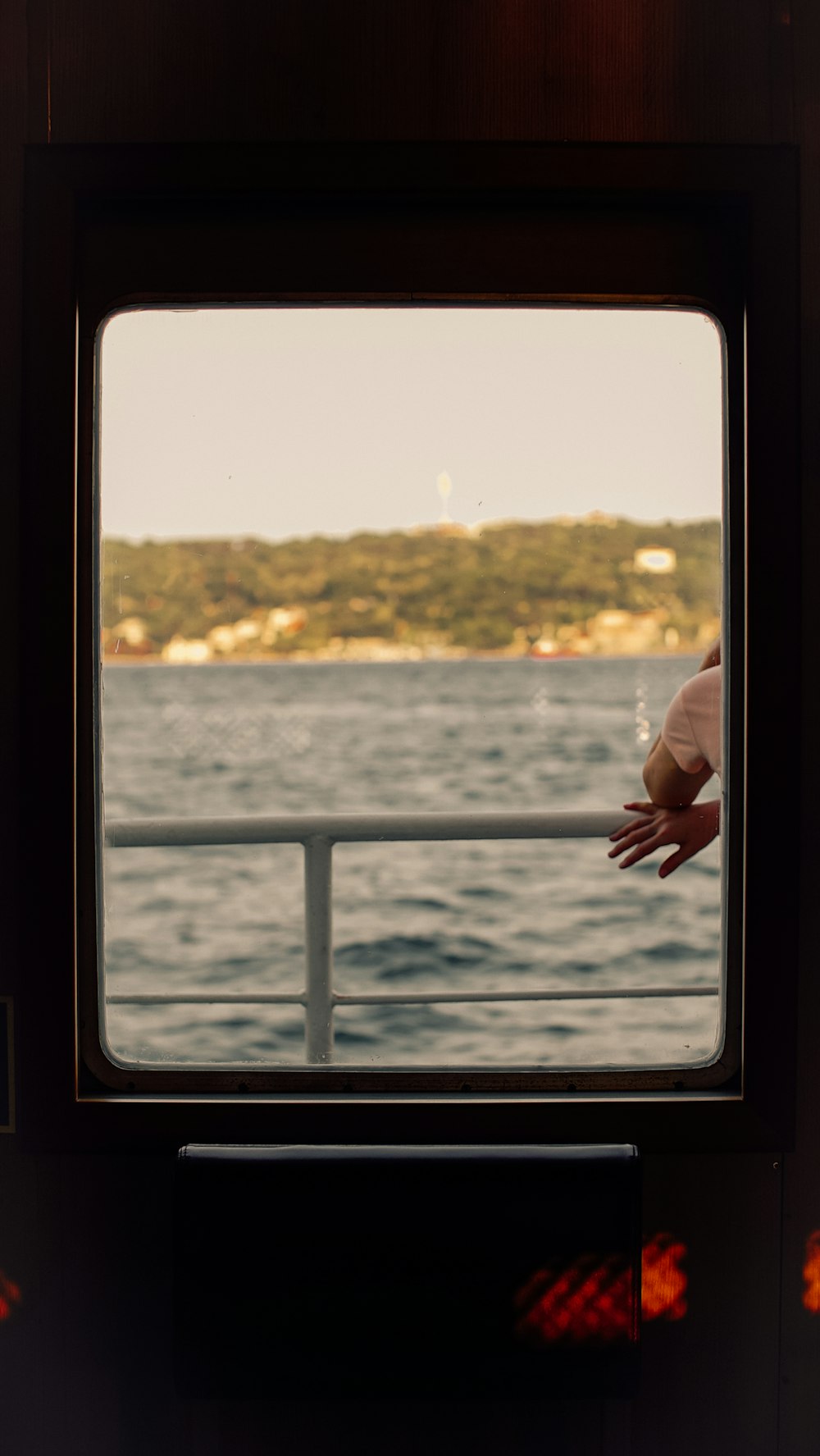 a person's hand is seen through the window of a boat