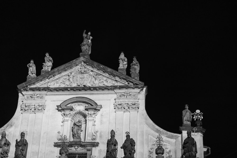 a black and white photo of a building with statues on it