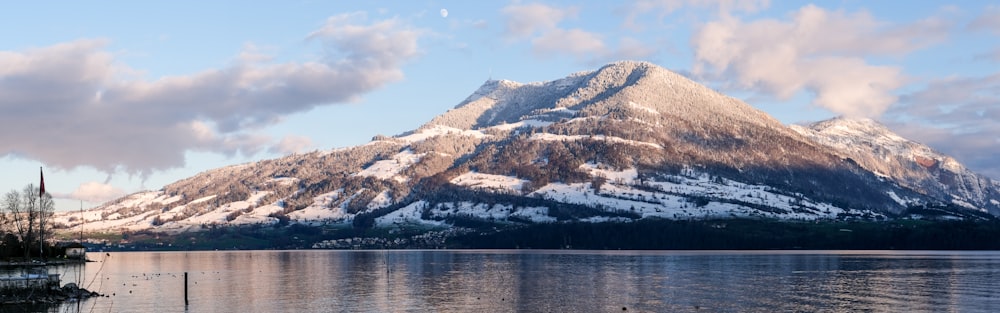 a snow covered mountain sitting above a lake