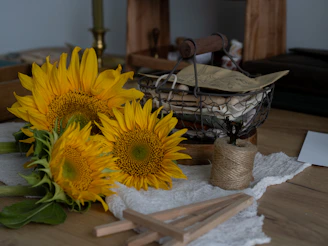 A cheerful bunch of sunflowers and wildflowers tied with a simple ribbon, resting on a wooden table.