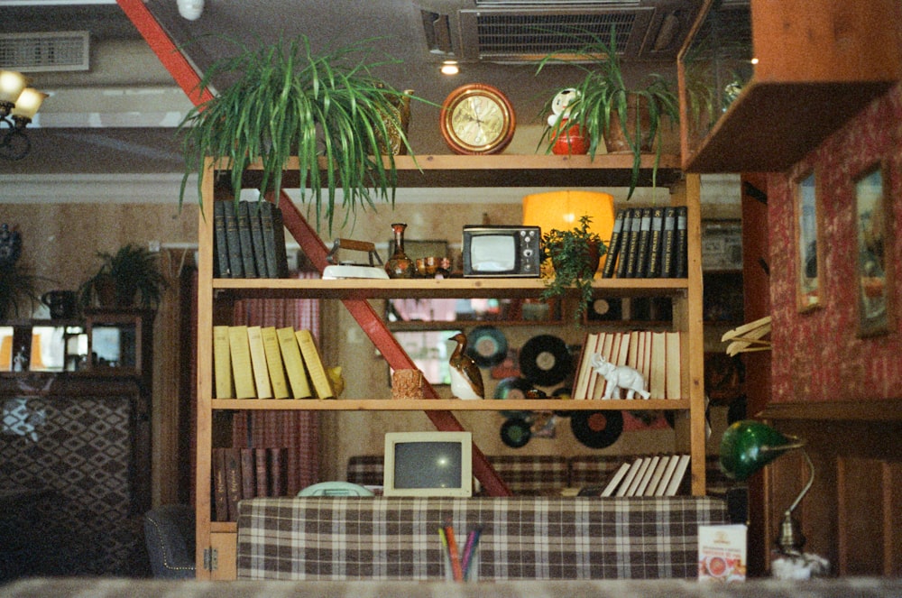 a bookshelf filled with lots of books and plants