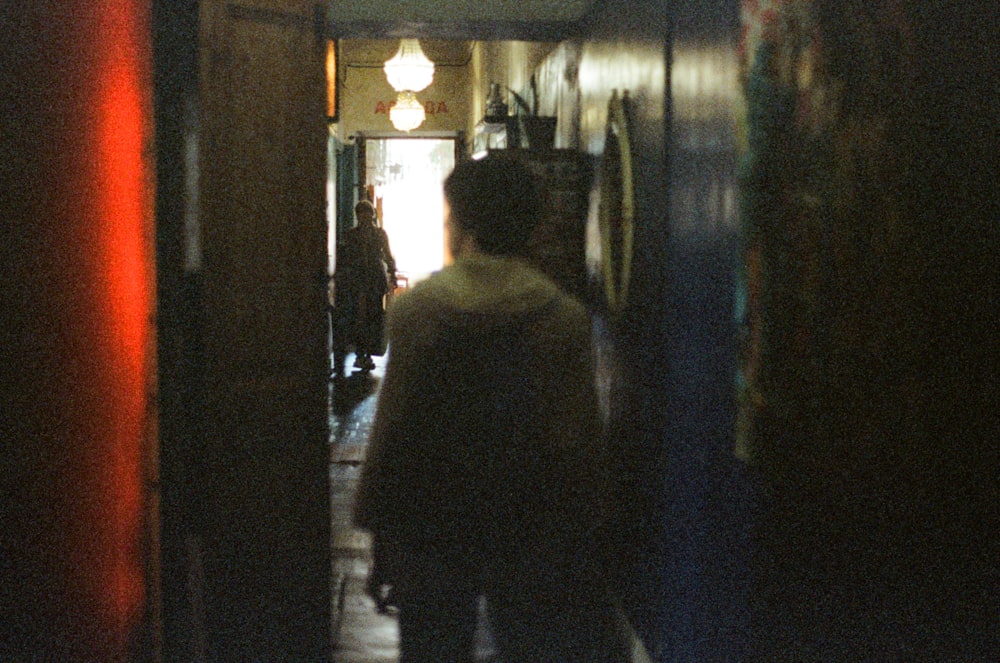 a blurry photo of a man walking down a hallway