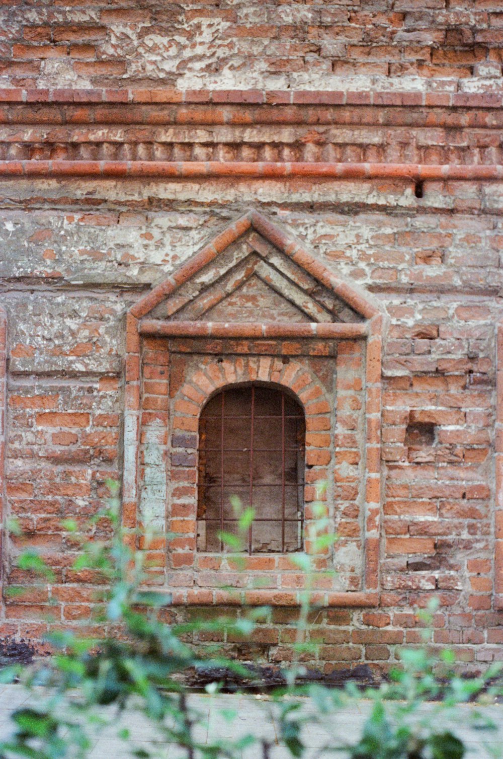 an old brick building with a window and bars