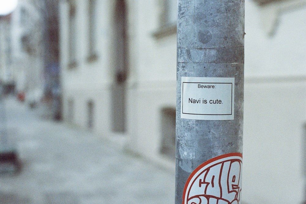 a sticker on a pole on a city street