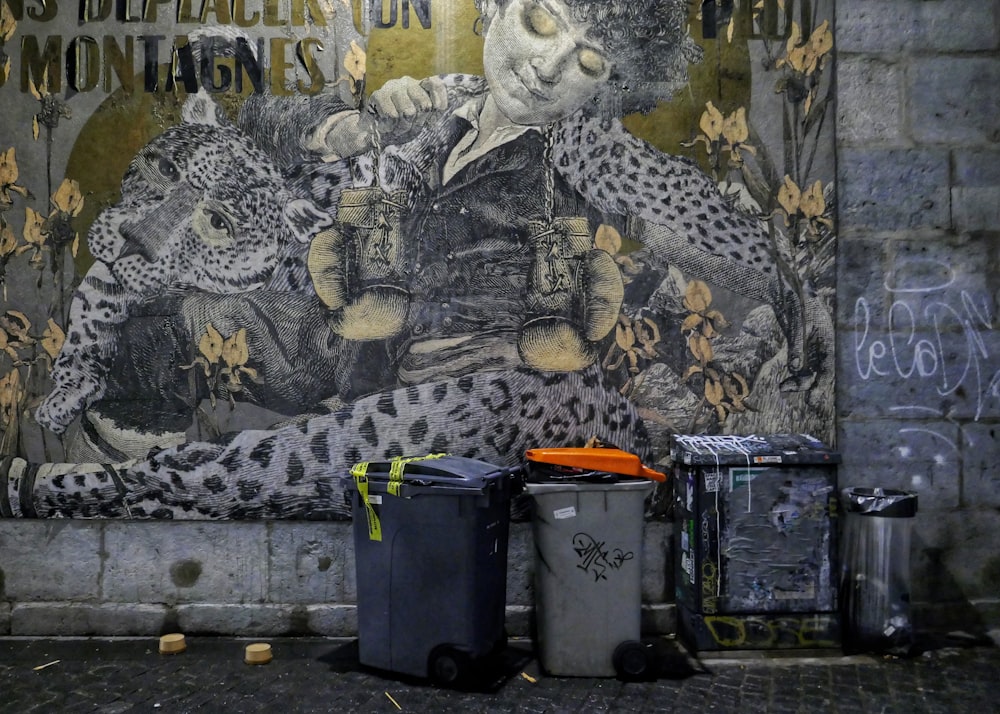 a mural on a wall with trash cans and garbage cans