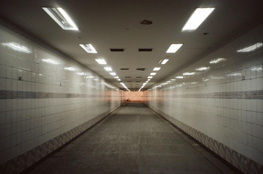 a long hallway with white walls and tiled floors