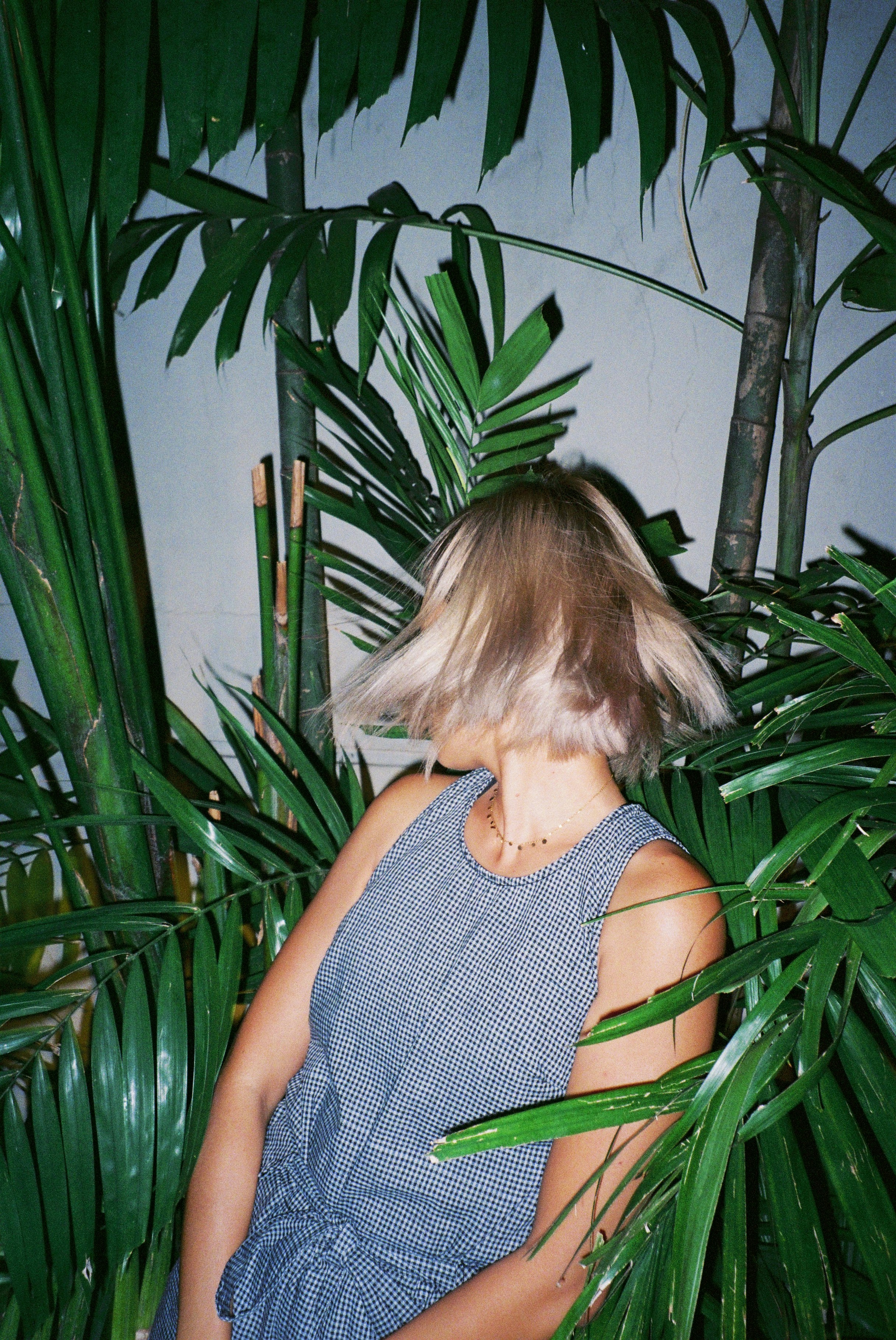 a woman standing in front of a palm tree
