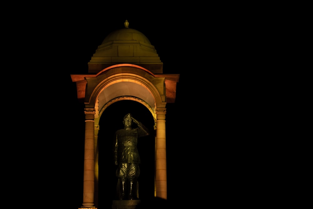 a clock tower with a statue in the middle of it