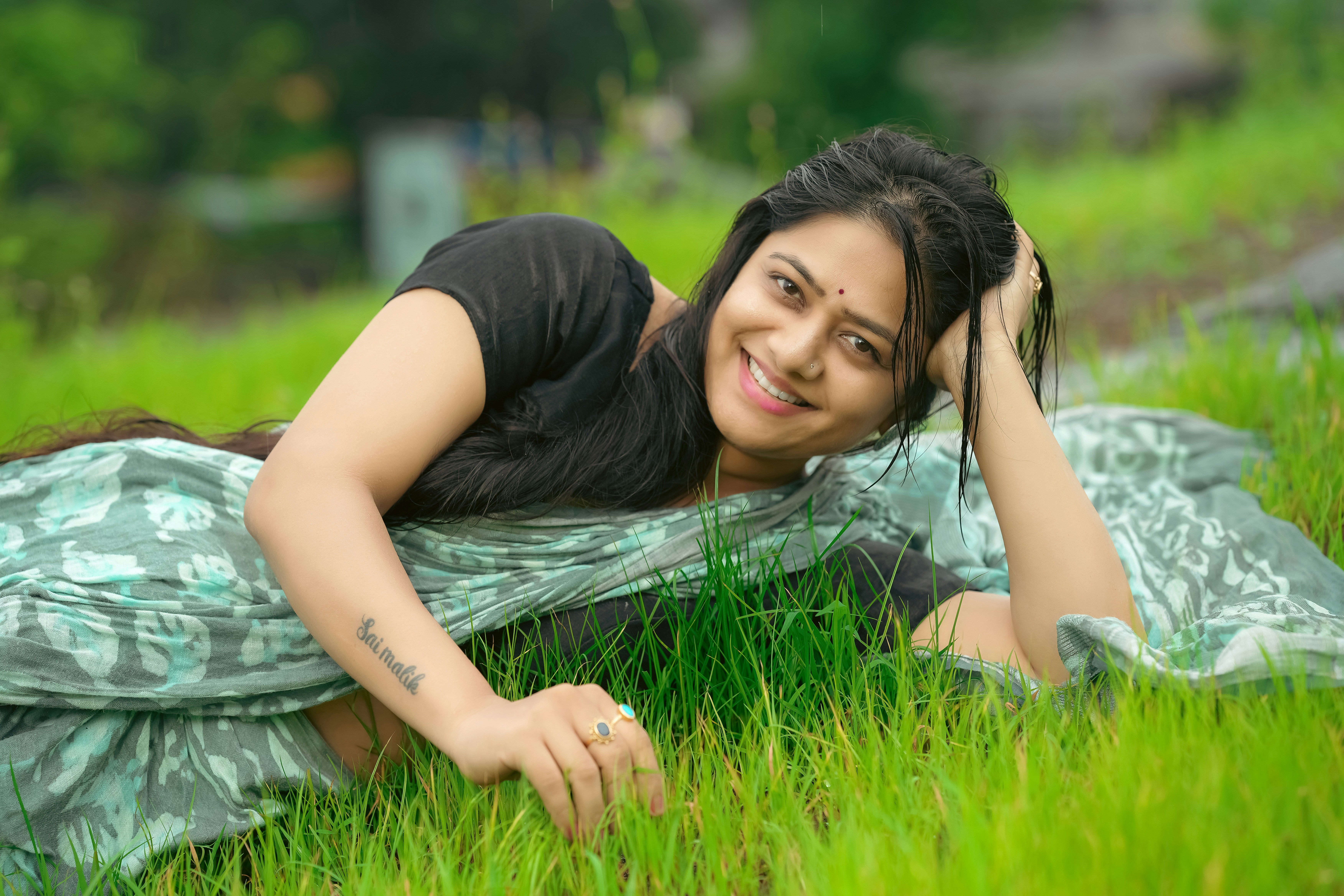 A woman laying in the grass with her hand on her head photo – Free Girl ...