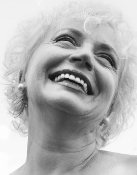 A joyful grandmother animated from a vintage black-and-white photo, smiling warmly.