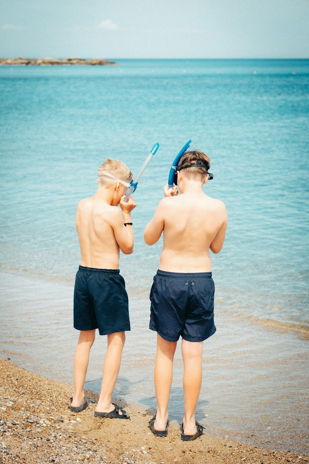 um casal de crianças em pé em cima de uma praia