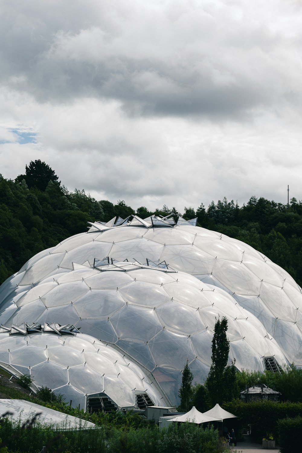 a large metal structure sitting on top of a lush green field