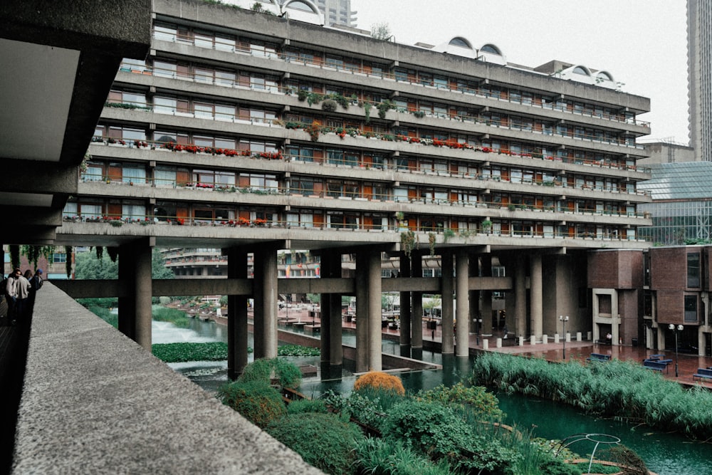 a very tall building with lots of windows next to a river