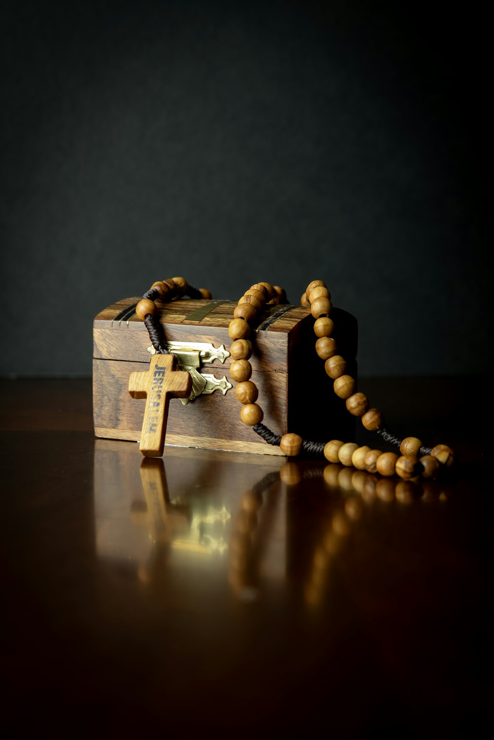 a wooden box with a rosary on it